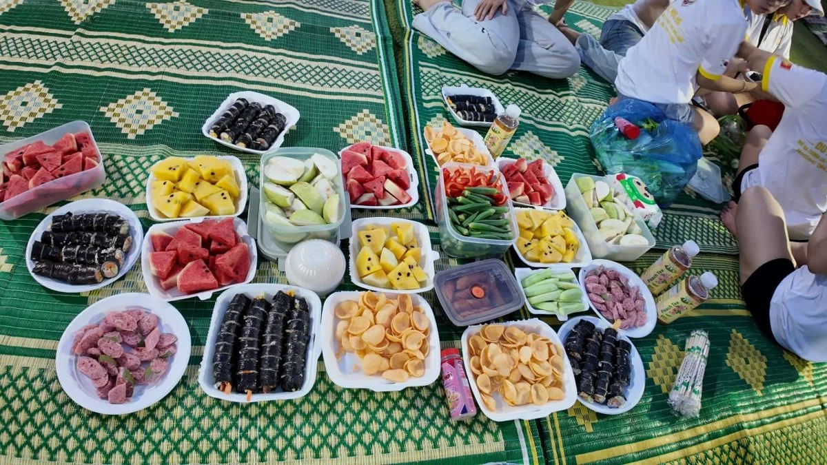 Cơm cuộn và hoa quả bày trên chiếu tại bãi cỏ cạnh biển Đồ Sơn