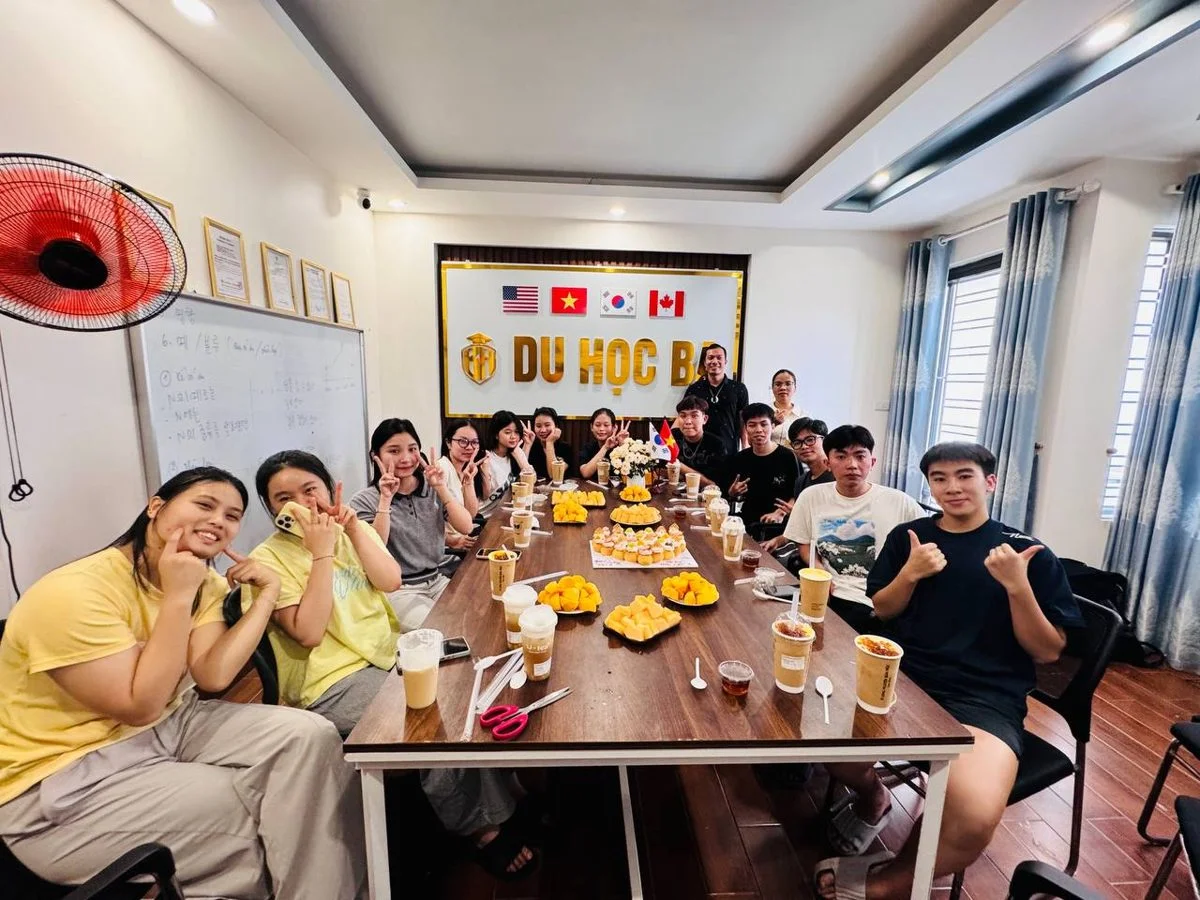 Học viên Du Học BA giơ tay chữ V bên bàn tiệc ngọt mừng 20/10 tại văn phòng Hải Phòng