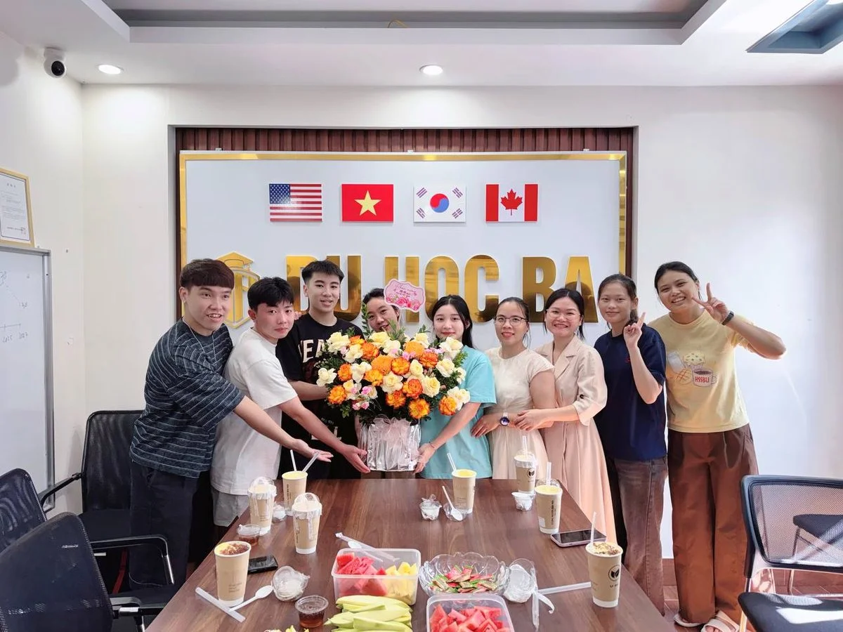 Các bạn nam du học sinh Du Học BA cùng các cô, các chị và bạn nữ đỡ lẵng hoa chúc mừng 20/10