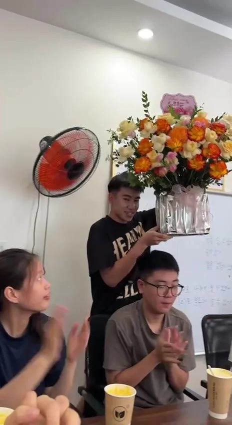 Bạn nam du học sinh bê lẵng hoa 20/10 vào phòng học Du Học BA, các bạn vỗ tay chào đón